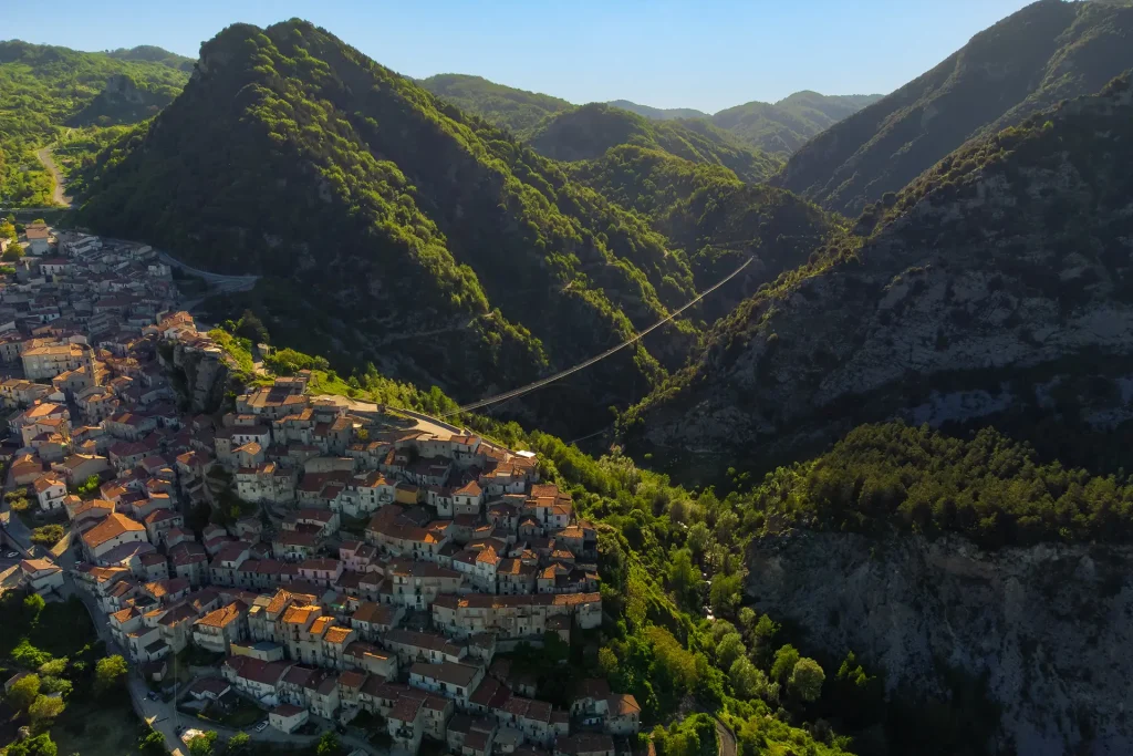 Il borgo di Castelsaraceno visto dall'alto, circondato dalle montagne verdeggianti del Parco Nazionale del Pollino.